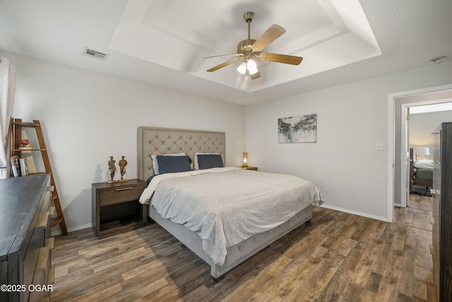 2238 Holly Ln, Miami, OK 74354 - bedroom featuring a tray ceiling, dark wood finished floors, and a ceiling fan