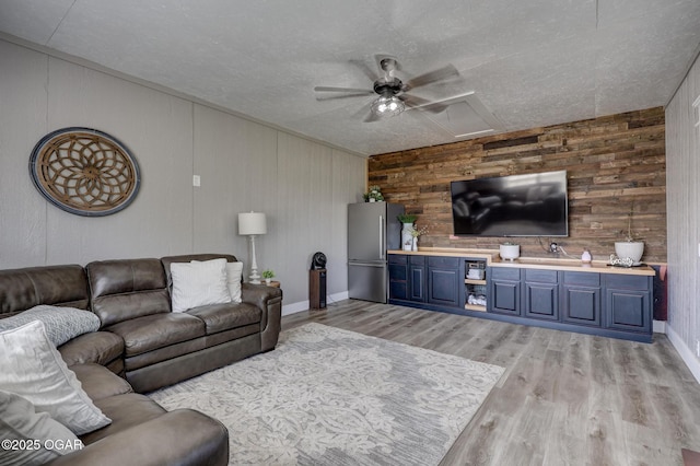 917 Monroe Cir, Carl Junction, MO 64834 - living area featuring a ceiling fan, wooden walls, light wood finished floors, and a textured ceiling