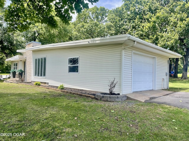 1060 Baxter St, Neosho, MO 64850 - view of side of property with a lawn, asphalt driveway, an attached garage, and a chimney
