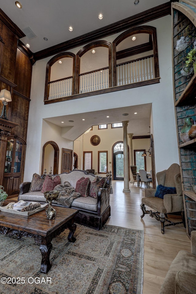 1126 Carrington Ter, Joplin, MO 64804 - living area with ornate columns, ornamental molding, a towering ceiling, and light wood-style floors