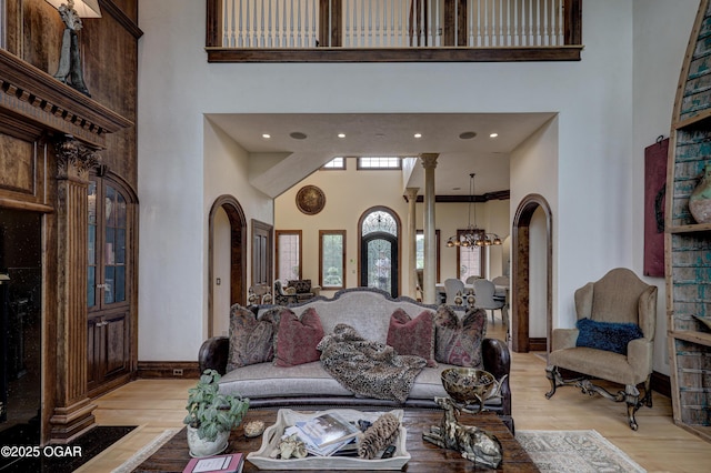 1126 Carrington Ter, Joplin, MO 64804 - living area featuring a towering ceiling, arched walkways, a chandelier, and light wood-style flooring