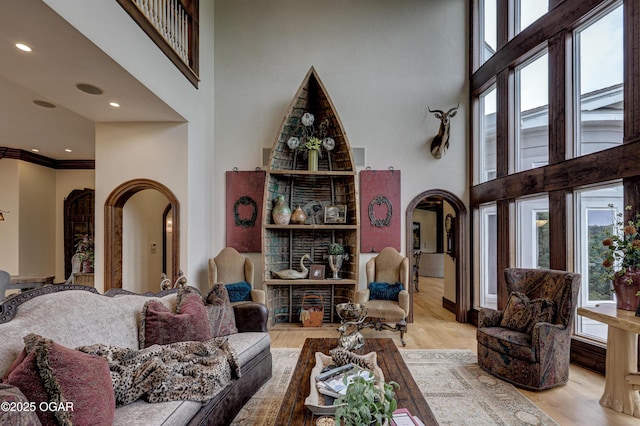 1126 Carrington Ter, Joplin, MO 64804 - living area with arched walkways, a towering ceiling, wood finished floors, and ornamental molding