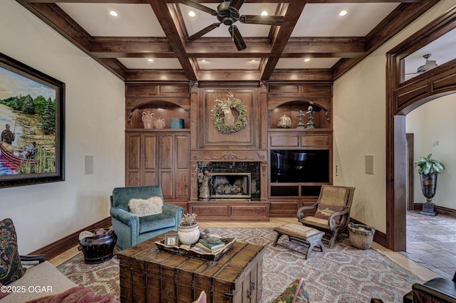 1126 Carrington Ter, Joplin, MO 64804 - living room featuring a high end fireplace, beamed ceiling, arched walkways, a ceiling fan, and coffered ceiling