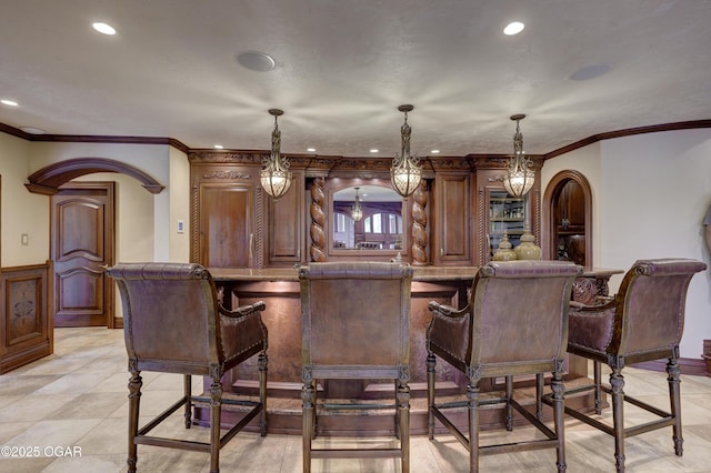 1126 Carrington Ter, Joplin, MO 64804 - bar area with arched walkways, recessed lighting, wainscoting, ornamental molding, and decorative light fixtures