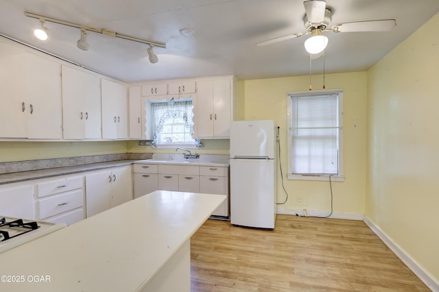 1123 Garden Grove Rd, Joplin, MO 64801 - kitchen featuring white appliances, track lighting, light wood-style flooring, white cabinetry, and light countertops