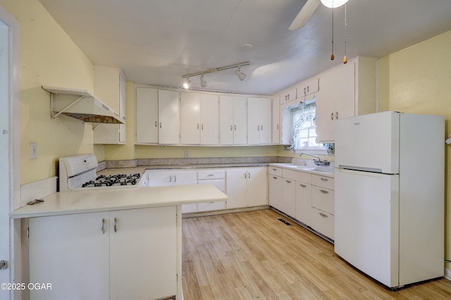 1123 Garden Grove Rd, Joplin, MO 64801 - kitchen featuring white appliances, custom exhaust hood, a peninsula, light wood-style flooring, and white cabinets