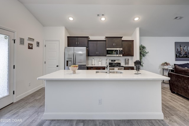 2008 Greydon Ln, Webb City, MO 64870 - kitchen featuring appliances with stainless steel finishes, dark brown cabinetry, light countertops, and a center island with sink