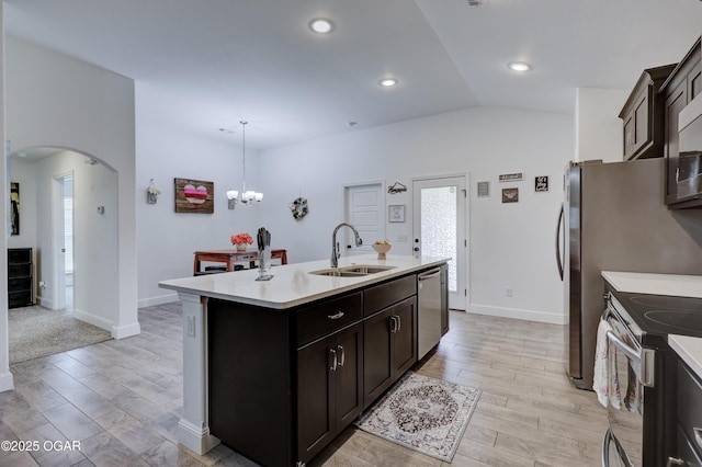 2008 Greydon Ln, Webb City, MO 64870 - kitchen featuring appliances with stainless steel finishes, arched walkways, light countertops, light wood-type flooring, and vaulted ceiling