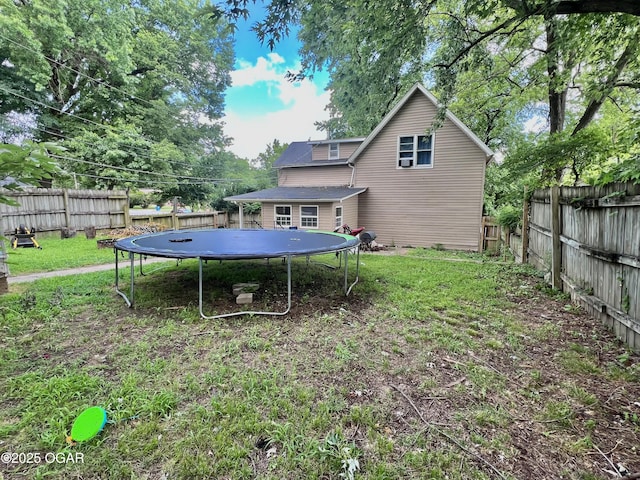 303 E Centennial Ave, Carthage, MO 64836 - rear view of property with a trampoline and a fenced backyard