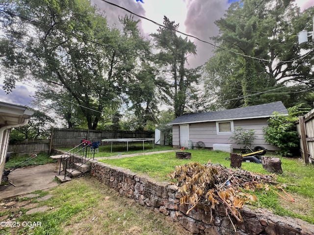 303 E Centennial Ave, Carthage, MO 64836 - fenced backyard with a trampoline, a patio area, and an outdoor structure