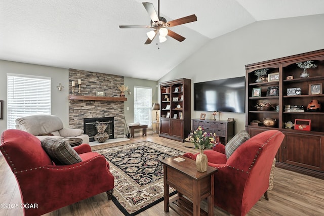 302 E 44th St, Joplin, MO 64804 - living room with ceiling fan, vaulted ceiling, a stone fireplace, and wood finished floors