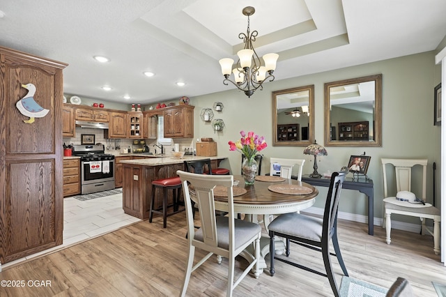 302 E 44th St, Joplin, MO 64804 - dining room with a chandelier, recessed lighting, light wood finished floors, and a tray ceiling