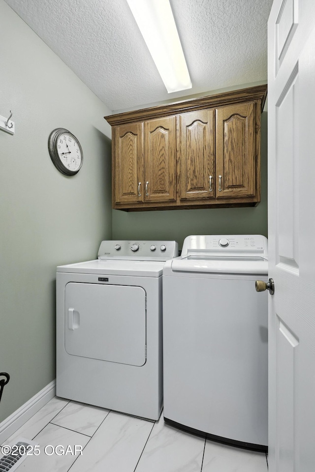 302 E 44th St, Joplin, MO 64804 - laundry area with washer and dryer, cabinet space, a textured ceiling, and light marble finish floors