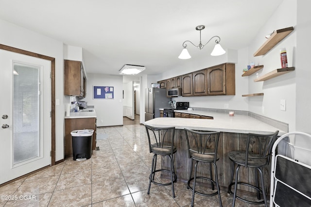 1901 Laura Ln, Joplin, MO 64801 - kitchen with appliances with stainless steel finishes, light countertops, a kitchen bar, a peninsula, and dark brown cabinets