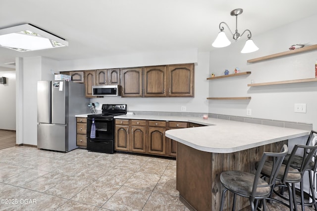 1901 Laura Ln, Joplin, MO 64801 - kitchen featuring stainless steel appliances, a peninsula, light countertops, a skylight, and decorative light fixtures