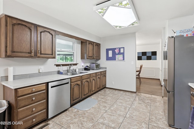 1901 Laura Ln, Joplin, MO 64801 - kitchen with stainless steel appliances, a skylight, light countertops, and light tile patterned flooring