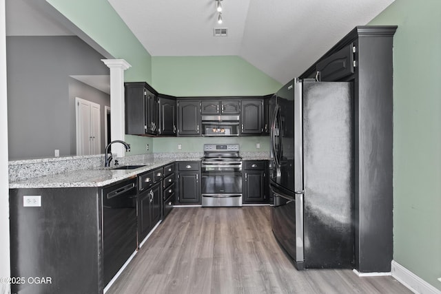 119 Jared Blvd, Webb City, MO 64870 - kitchen featuring appliances with stainless steel finishes, lofted ceiling, light wood-style flooring, light stone countertops, and decorative columns