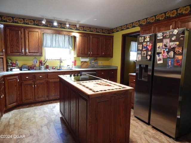 3065 Coyote Dr, Joplin, MO 64804 - kitchen with refrigerator with ice dispenser, a kitchen island, light countertops, rail lighting, and black electric stovetop