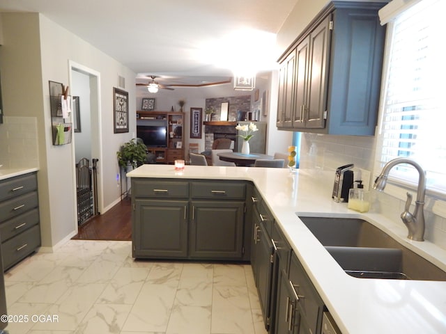 2722 E Wickersham Rd, Joplin, MO 64804 - kitchen with a peninsula, a ceiling fan, tasteful backsplash, and light countertops