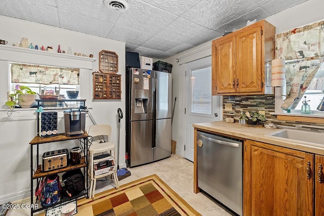 417 S Mcgregor St, Carthage, MO 64836 - kitchen with appliances with stainless steel finishes, decorative backsplash, brown cabinets, and an ornate ceiling