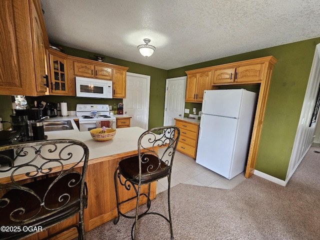 2813 Heartland Ave, Joplin, MO 64804 - kitchen featuring white appliances, a peninsula, glass insert cabinets, light colored carpet, and a textured ceiling