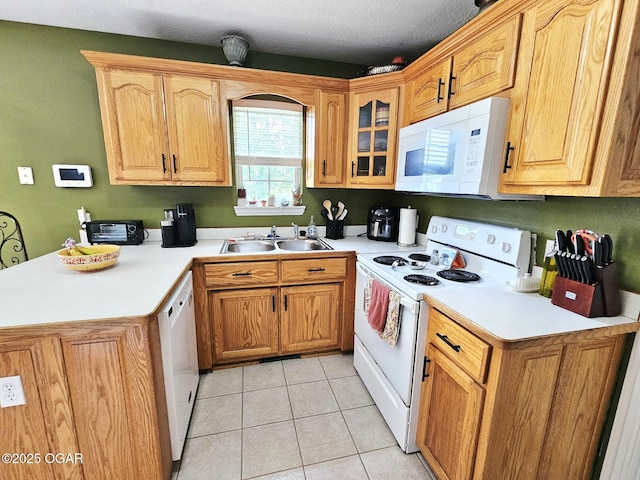 2813 Heartland Ave, Joplin, MO 64804 - kitchen featuring white appliances, a peninsula, light countertops, light tile patterned floors, and glass insert cabinets
