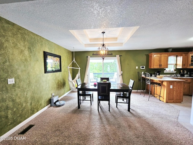2813 Heartland Ave, Joplin, MO 64804 - dining space with a textured ceiling, light carpet, a tray ceiling, and a textured wall