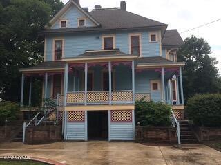 729 W Central Ave, Carthage, MO 64836 - view of front of property with stairs, a porch, a chimney, and driveway
