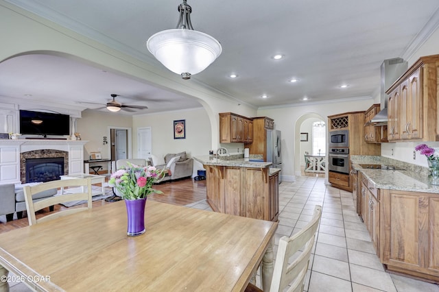3510 Notting Hill Cir, Joplin, MO 64804 - dining area featuring arched walkways, light tile patterned floors, a glass covered fireplace, a ceiling fan, and crown molding