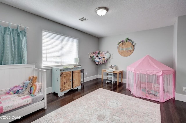 3510 Notting Hill Cir, Joplin, MO 64804 - bedroom with dark wood-style floors, a textured ceiling, and a crib