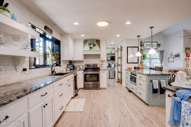 11284 Norway Rd, Neosho, MO 64850 - kitchen featuring appliances with stainless steel finishes, custom exhaust hood, stone countertops, light wood-style floors, and white cabinets