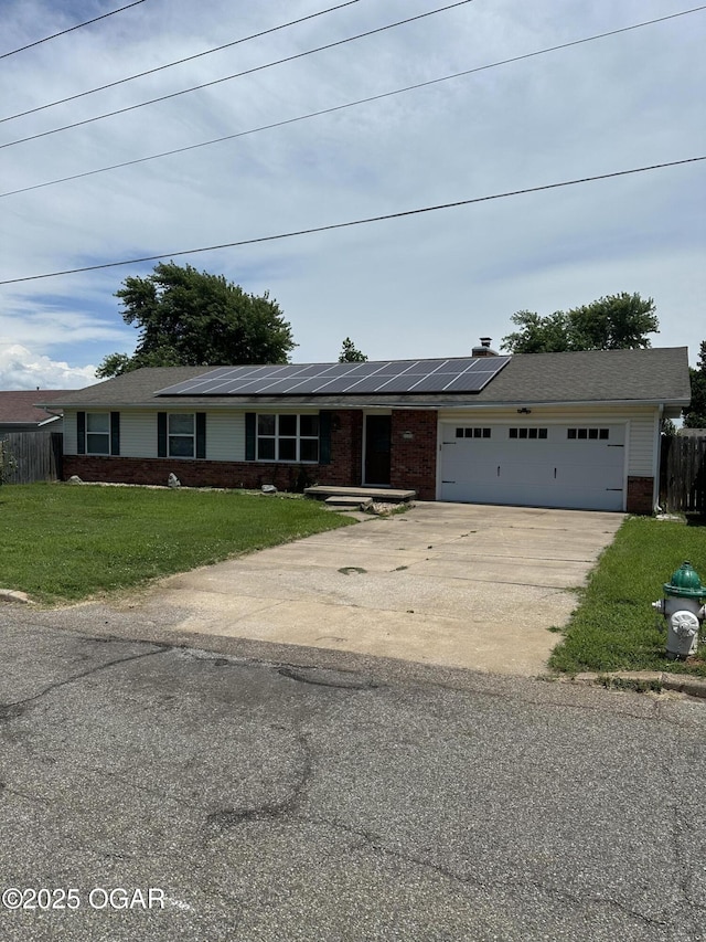 2223 Texas Ave, Joplin, MO 64804 - view of front of property with brick siding, concrete driveway, roof mounted solar panels, and a garage