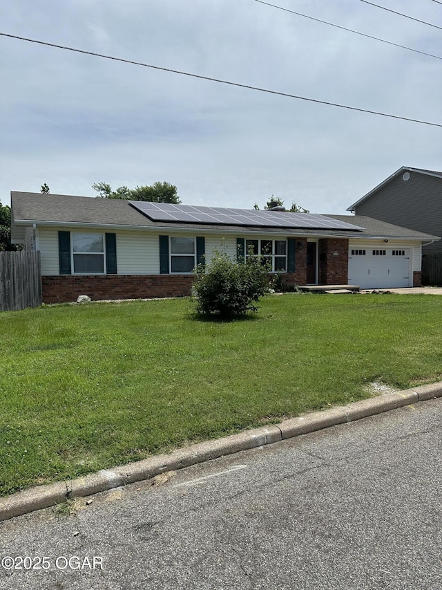 2223 Texas Ave, Joplin, MO 64804 - view of front of property featuring brick siding, solar panels, and a garage