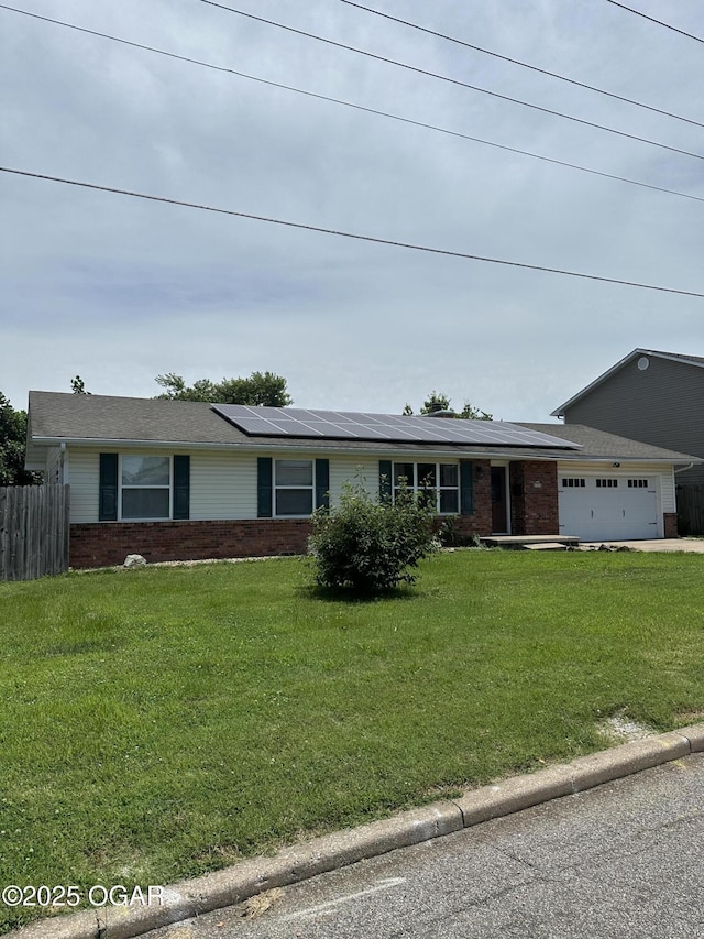 2223 Texas Ave, Joplin, MO 64804 - ranch-style home featuring brick siding, a garage, roof mounted solar panels, and concrete driveway
