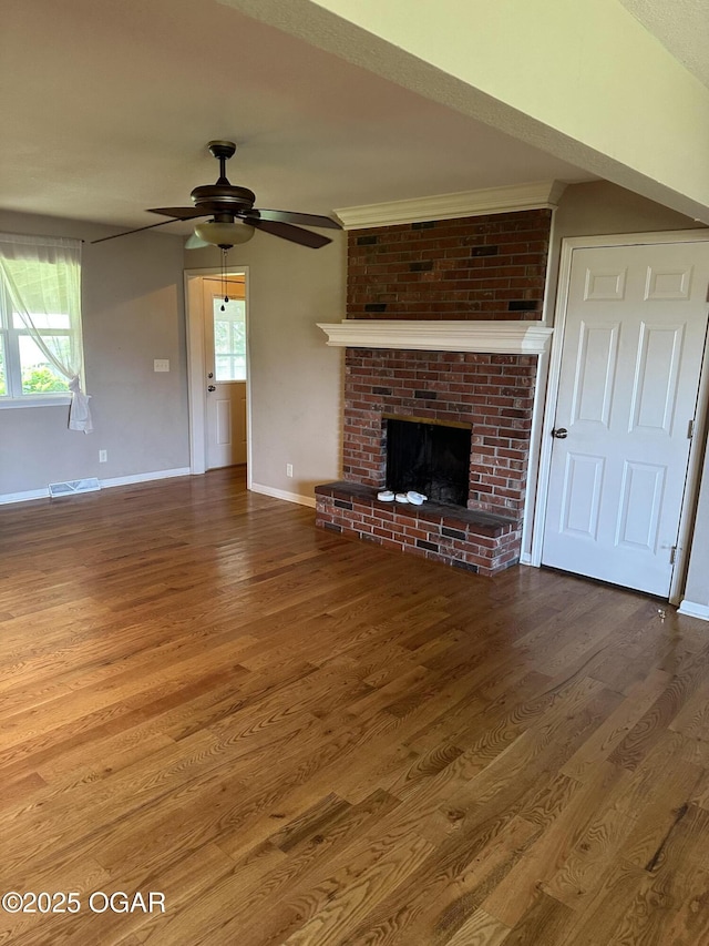 2223 Texas Ave, Joplin, MO 64804 - unfurnished living room featuring wood finished floors, a ceiling fan, healthy amount of natural light, and a fireplace