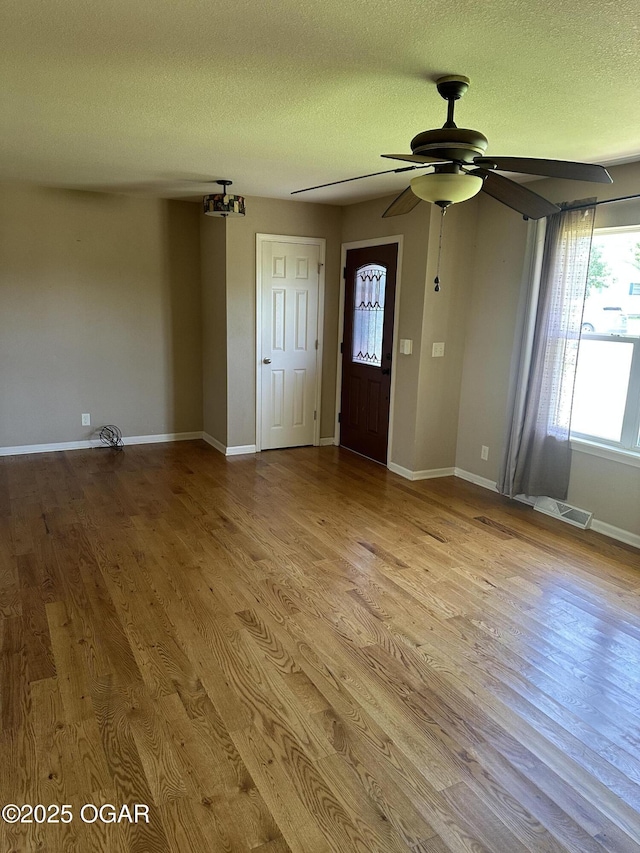 2223 Texas Ave, Joplin, MO 64804 - unfurnished living room with wood finished floors, a ceiling fan, and a textured ceiling