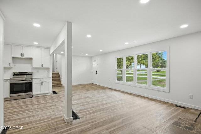 12807 Larissa Ln, Neosho, MO 64850 - unfurnished living room featuring recessed lighting, stairs, and light wood finished floors