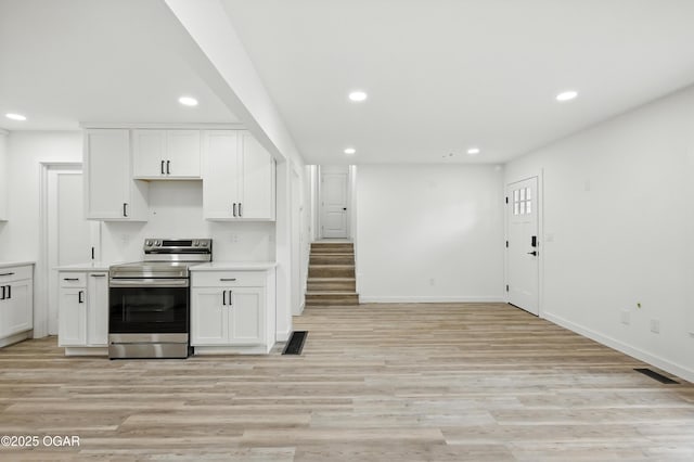 12807 Larissa Ln, Neosho, MO 64850 - kitchen featuring electric range, recessed lighting, white cabinets, and light wood-style floors