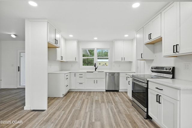 12807 Larissa Ln, Neosho, MO 64850 - kitchen featuring appliances with stainless steel finishes, light wood-style floors, recessed lighting, white cabinetry, and light countertops