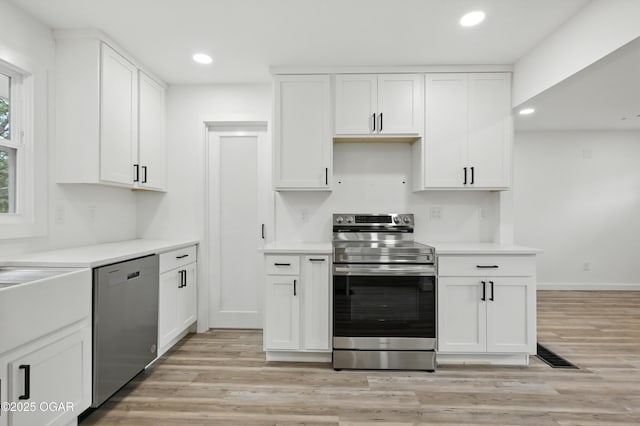 12807 Larissa Ln, Neosho, MO 64850 - kitchen featuring stainless steel appliances, light wood finished floors, recessed lighting, white cabinets, and light countertops