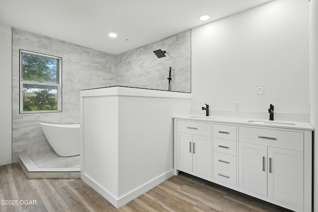 12807 Larissa Ln, Neosho, MO 64850 - full bath with a freestanding bath, a walk in shower, wood finished floors, double vanity, and recessed lighting