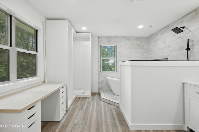 12807 Larissa Ln, Neosho, MO 64850 - bathroom with a walk in shower, vanity, a freestanding bath, wood finished floors, and recessed lighting
