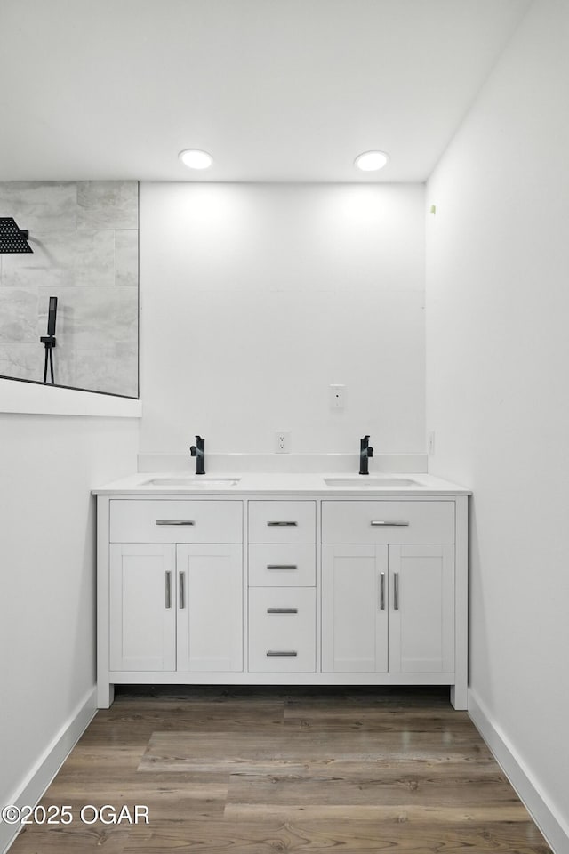 12807 Larissa Ln, Neosho, MO 64850 - bathroom featuring double vanity, a tile shower, recessed lighting, and wood finished floors