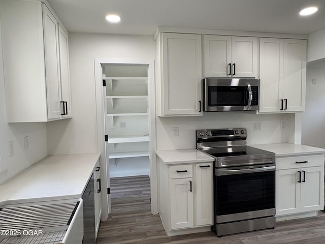 12807 Larissa Ln, Neosho, MO 64850 - kitchen with appliances with stainless steel finishes, wood finished floors, white cabinetry, and recessed lighting