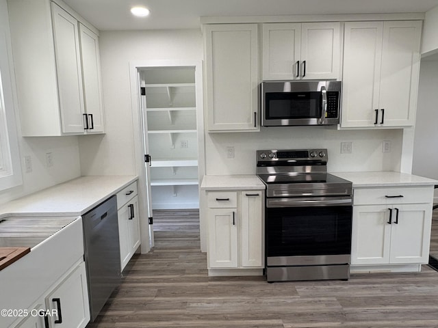 12807 Larissa Ln, Neosho, MO 64850 - kitchen featuring appliances with stainless steel finishes, light wood-style flooring, white cabinets, recessed lighting, and light countertops