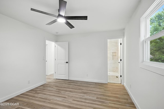 12807 Larissa Ln, Neosho, MO 64850 - unfurnished bedroom featuring light wood finished floors, connected bathroom, and a ceiling fan