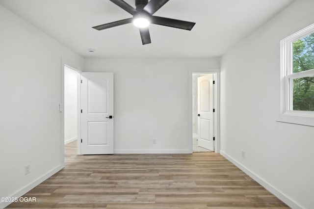 12807 Larissa Ln, Neosho, MO 64850 - unfurnished bedroom with light wood-style flooring, ensuite bath, and a ceiling fan