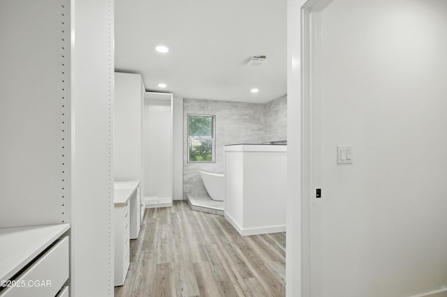 12807 Larissa Ln, Neosho, MO 64850 - bathroom with vanity, a freestanding tub, wood finished floors, and recessed lighting