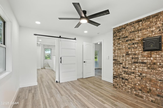 12807 Larissa Ln, Neosho, MO 64850 - spare room with a barn door, ceiling fan, light wood-type flooring, and recessed lighting
