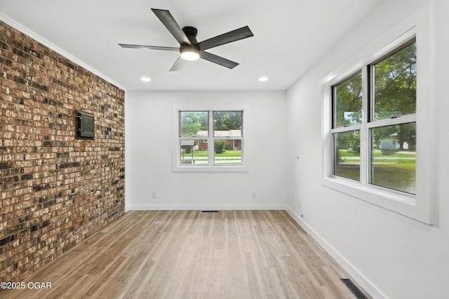 12807 Larissa Ln, Neosho, MO 64850 - empty room featuring brick wall, light wood-style flooring, ceiling fan, and recessed lighting